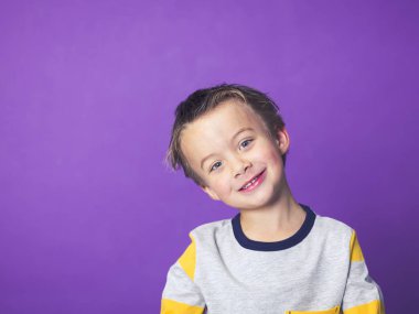 Menekşe arka plan önünde poz eğleniyor mutlu küçük çocuk