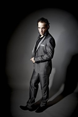 handsome businessman model in suit posing on dark studio background 