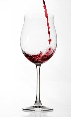 kırmızı şarap kadehinin beyaz zemin üzerine izole içinde dökme yakın çekim 