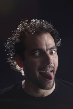 sakallı Brunet adam yapması, çapraz gözleri ve gösteren dil dışarı, yakın-up portre