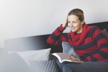 yastık ile kanepede oturan ve oturma odası, macera kitap okuma güzel kadın 