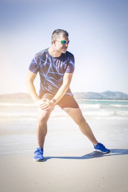 atletik adam tropik sahilde güneşli gün germe 