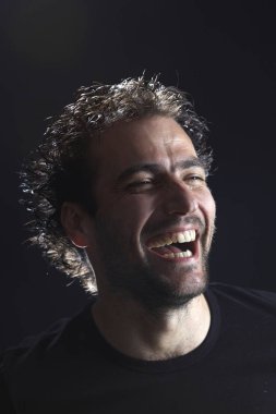 koyu arka planda gülüyor sakallı Brunet adam portre, yakın çekim