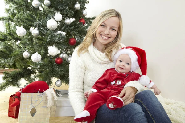 Мама Веселится Обнимая Милого Ребенка Красном Костюме Санта Клауса Рядом — стоковое фото