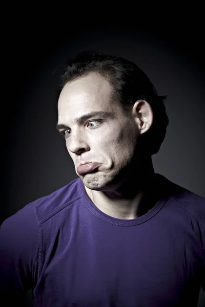 Retrato Hombre Emocional Jersey Púrpura Haciendo Muecas Sobre Fondo Oscuro — Foto de Stock