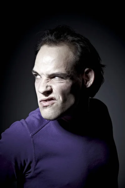 Retrato Hombre Emocional Jersey Púrpura Haciendo Muecas Sobre Fondo Oscuro — Foto de Stock