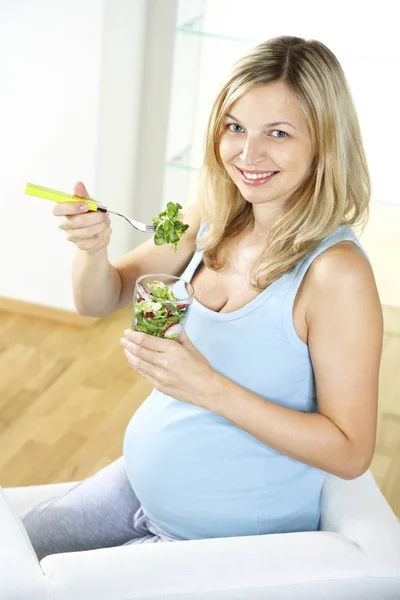 Gelukkig Zwangere Vrouw Zittend Een Fauteuil Salade Van Glas Thuis — Stockfoto