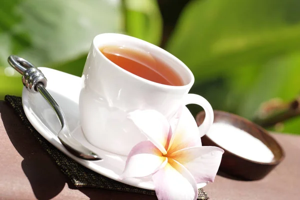 Tasse Tee Mit Blume Und Löffel Auf Verschwommenem Grünem Hintergrund — Stockfoto