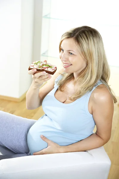 Gelukkig Zwangere Vrouw Zittend Een Stoel Radijs Sandwich Thuis Eten — Stockfoto