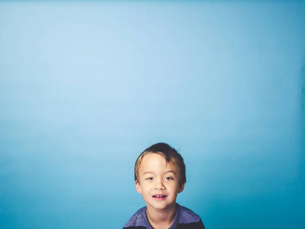 Mavi Arka Plan Önünde Poz Mutlu Küçük Çocuk — Stok fotoğraf