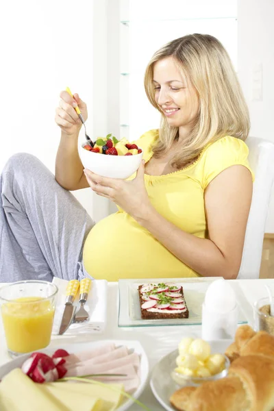 Feliz Mujer Embarazada Sentada Silla Comiendo Ensalada Frutas Del Tazón —  Fotos de Stock