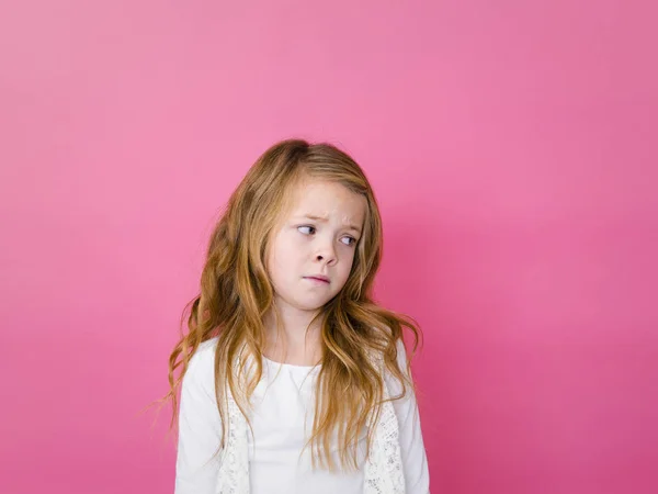 ピンクの背景の白い服でヨダレのかわいい女の子の肖像画 — ストック写真