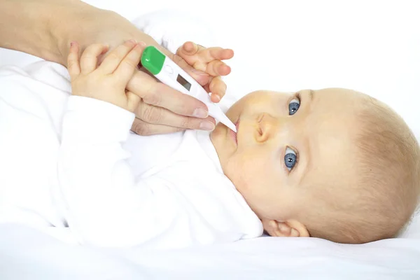 woman measuring temperature of seven month old baby with digital thermometer