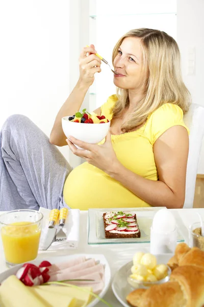 Feliz Mujer Embarazada Sentada Silla Comiendo Ensalada Frutas Del Tazón —  Fotos de Stock