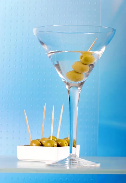 Glas Martini Und Teller Mit Grünen Oliven Auf Blauem Hintergrund — Stockfoto