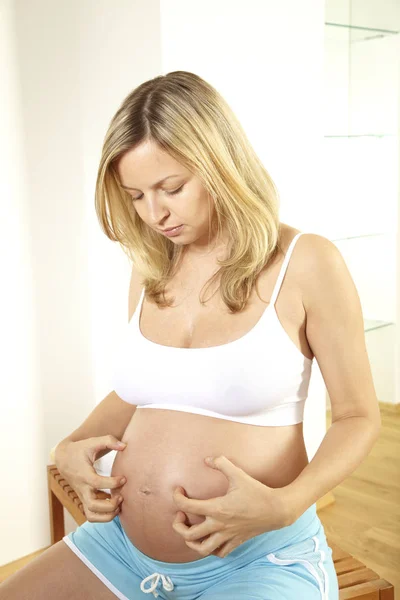 Blonde Zwangere Vrouw Ondergoed Buik Krabben — Stockfoto