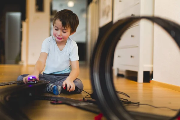 スロットカー レース トラックを自宅のモデルで遊んで金髪の少年 — ストック写真