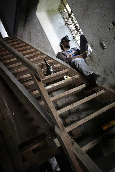 Borracho Barbudo Mendigo Celebración Lata Cerveza Durmiendo Windowsill Cerca Escaleras — Foto de Stock