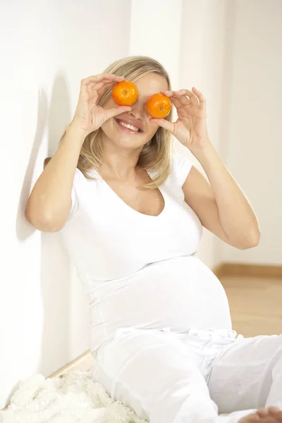 Heureuse Femme Enceinte Tenant Des Mandarines Devant Les Yeux Souriant — Photo