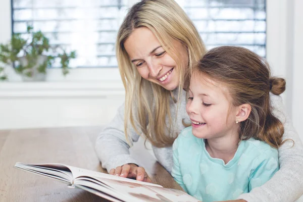 Mãe Com Livro Ensinando Filha Ler Casa — Fotografia de Stock