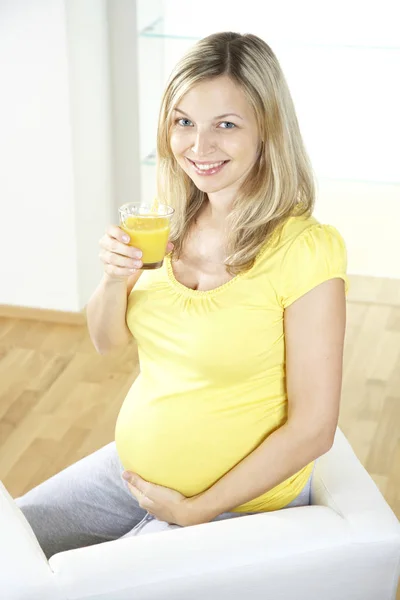 Happy Pregnant Woman Sitting Armchair Drinking Orange Juice Glass Home Stock Picture