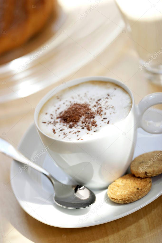 white cup of coffee with crispy cookies, close-up 