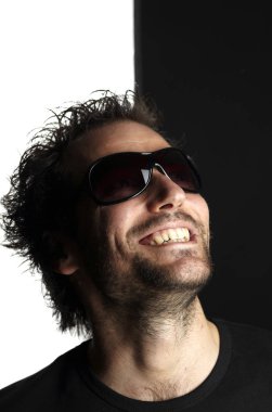 siyah ve beyaz arka planda gülümseyen güneş gözlüğü komik adam portre 