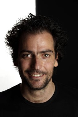 sakallı Brunet adam kamera bakıyor ve siyah beyaz arka planda gülümseyen portre, yakın çekim