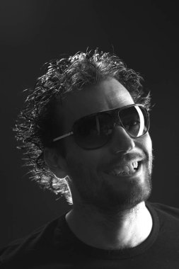 karanlık arka planda gülümseyen güneş gözlüğü komik adam portre 