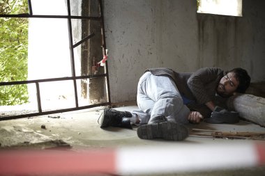 kirli elbiseli dilenci adam yerde yatan ve ihmal edilen binada uyku 