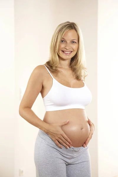 Ξανθιά Έγκυος Γυναίκα Κοίλο Κοιλιά Της Δύο Χέρια Και Χαμογελάει — Φωτογραφία Αρχείου