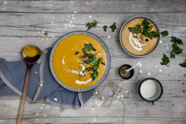 ahşap masa, balkabağı çorbası ile plakalar yakın çekim 