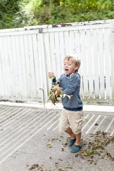 Kleiner Lustiger Junge Spielt Mit Herbstblättern Der Nähe Von Holzzaun — Stockfoto