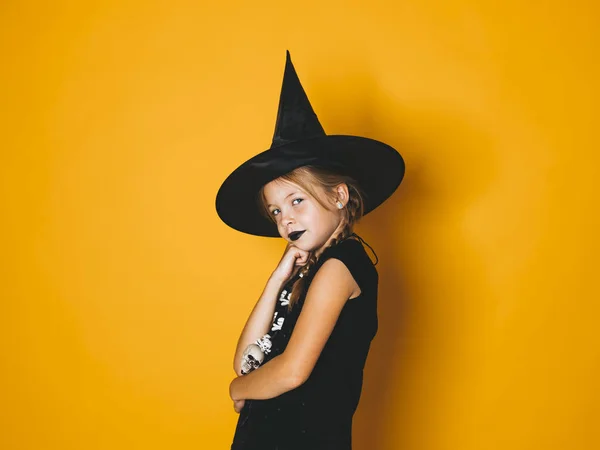 Dziewczynka Halloween Kostium Czarownicy Czarny Kapelusz Patrząc Kamery Poważne Ręką — Zdjęcie stockowe