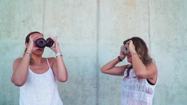 Dos Hermosas Mujeres Divierten Con Donuts Mientras Están Pie Cerca — Vídeos de Stock