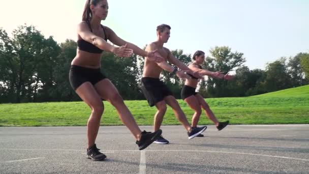 Vrouwen Met Man Doen Pistool Squats Stadium — Stockvideo