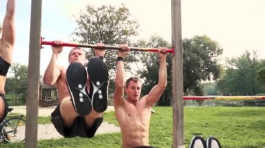 stadyum üzerinde yatay barda egzersizleri yaparken eğitim kadın ile iki erkek sporcular