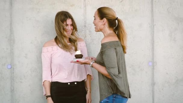 两个美丽的女人一起享受 而倒五颜六色的糖洒松饼上的五彩纸屑 — 图库视频影像