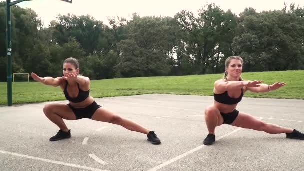 Two Women Doing Side Lunges Stadium — Stock Video