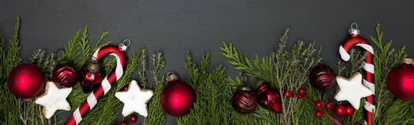 モミの枝上の Cookie と赤のクリスマス アイテムのコレクションを持つ灰色のクリスマス背景 — ストック写真