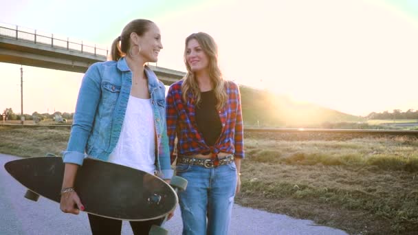 Dos Mujeres Disfrutando Juntas Mientras Caminan Con Monopatín Atardecer — Vídeos de Stock