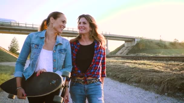 Dos Mujeres Disfrutando Juntas Mientras Caminan Con Monopatín Atardecer — Vídeo de stock