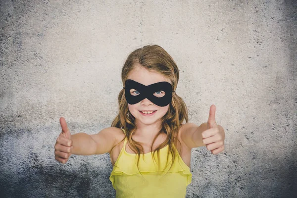 Blond Girl Black Superhero Mask Yellow Shirt Posing Front Concrete — Stock Photo, Image