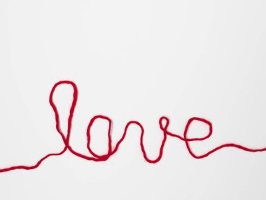 kırmızı iplik izole beyaz arka plan, yakın çekim, Sevgililer günü kavramı ile yazılı kelime aşk  