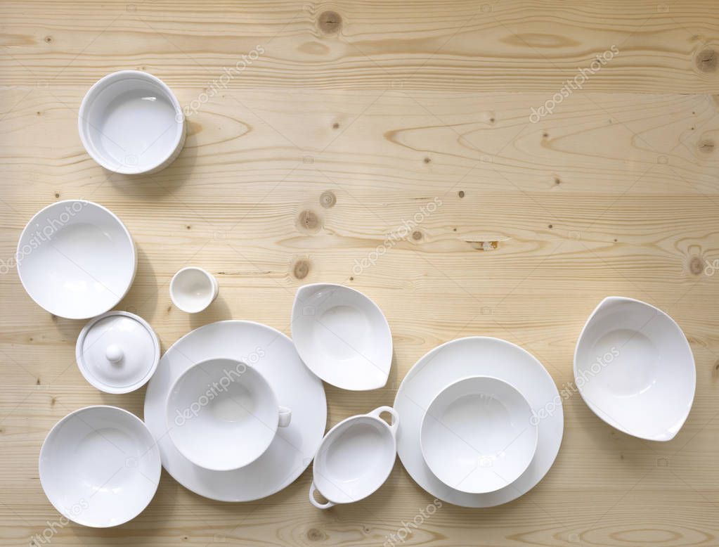 collection of modern white crockery on light wooden background