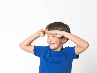 altı yaşında bir çocuk mavi mavi gözlü portresi alnına elini tutarak ve bir kenara seyir t-shirt beyaz arka plan üzerinde izole.