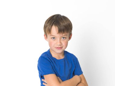 altı yaşında bir çocuk mavi t-shirt beyaz arka plan üzerinde izole kamera dikkatle bakarak mavi gözlü portresi