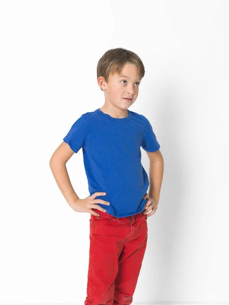 自信的6岁男孩穿着红色裤子和蓝色 T恤摆在腰带上的手 — 图库照片