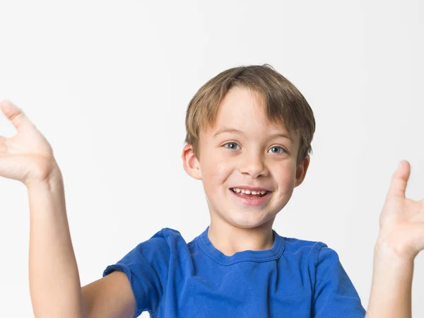 6岁男孩的肖像穿着蓝色 T恤站在离婚的手和微笑隔离在白色背景 — 图库照片