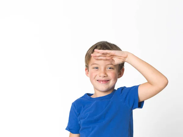 6岁男孩的肖像与蓝色眼睛在蓝色 T恤举行手在额头上 向前看被隔绝在白色背景 — 图库照片